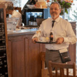Kellner im HASE Restaurant serviert Wein – festliche Stimmung an in Köln